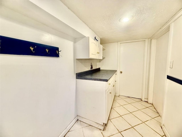 115 W 32nd St, Erie, PA 16508 - kitchen featuring dark countertops, white cabinetry, tasteful backsplash, a textured ceiling, and light tile patterned floors