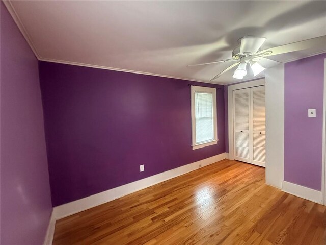 115 W 32nd St, Erie, PA 16508 - unfurnished bedroom with light wood-style flooring, a closet, ornamental molding, and a ceiling fan