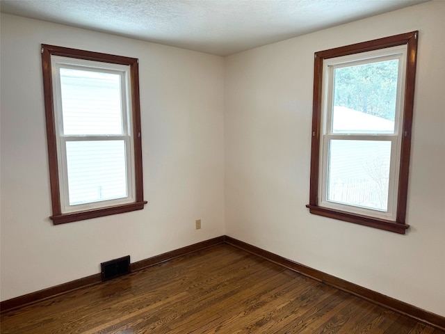 empty room with dark wood-type flooring