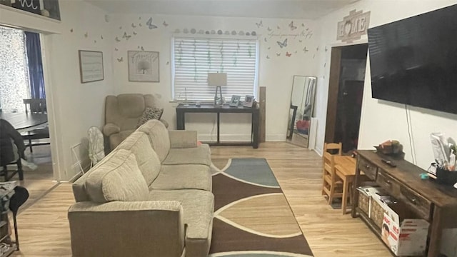 living room with plenty of natural light and light hardwood / wood-style flooring