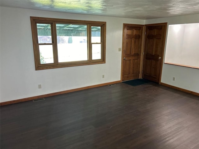 unfurnished room with dark hardwood / wood-style flooring