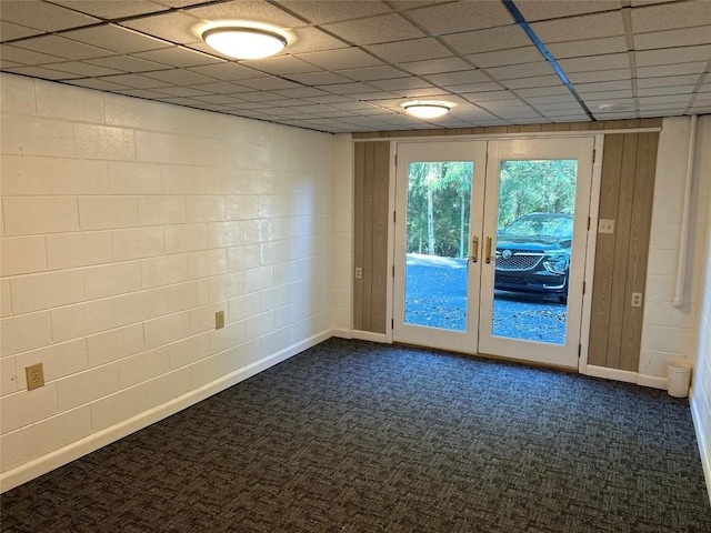 unfurnished room featuring dark colored carpet, french doors, and a paneled ceiling