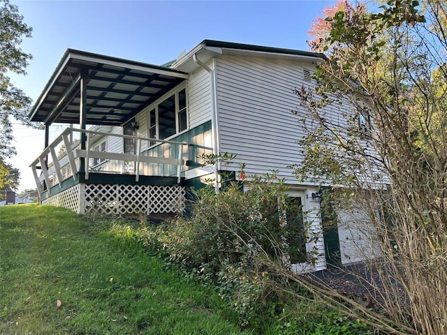 view of side of home featuring a lawn and a porch