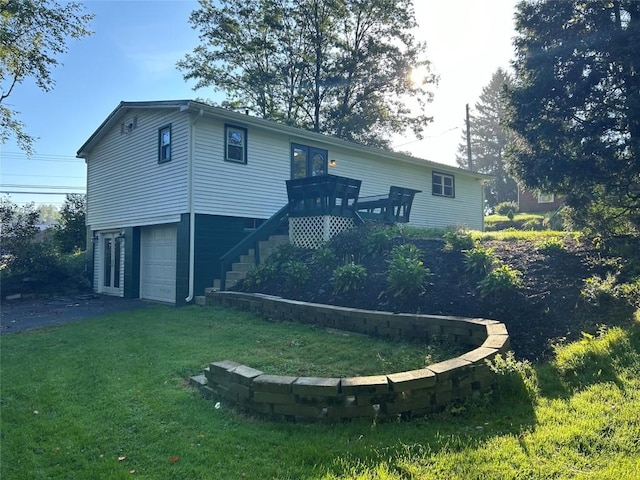 rear view of house with a yard, a garage, and a deck