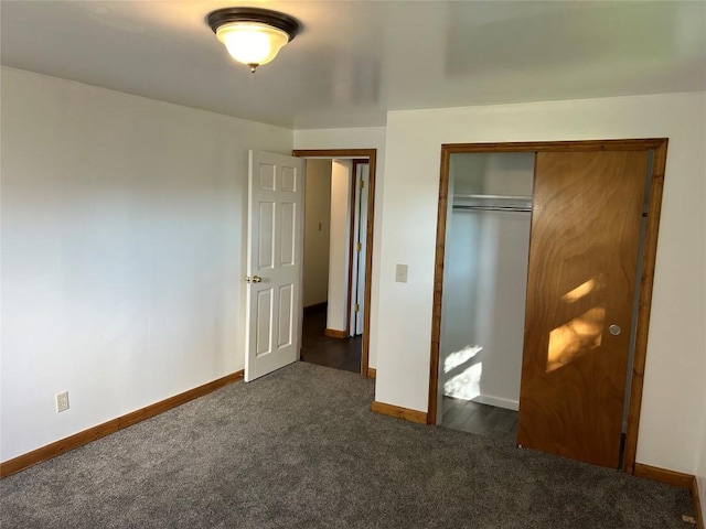 unfurnished bedroom with dark carpet and a closet