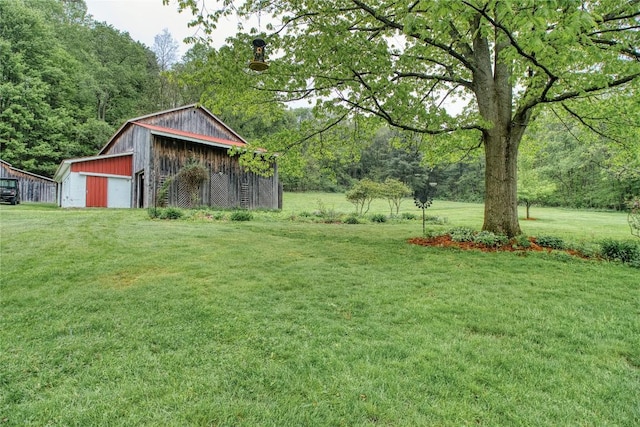 23186 Hatchtown Rd, Spartansburg, PA 16434 - view of grassy yard with a garage, an outdoor structure, a pole building, and a view of trees