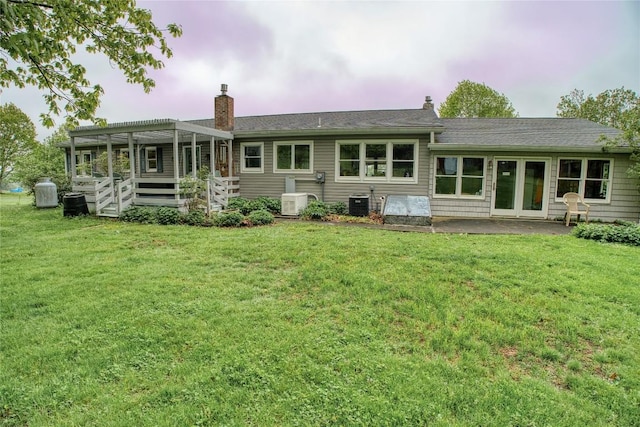 23186 Hatchtown Rd, Spartansburg, PA 16434 - back of property featuring a yard, central AC unit, a chimney, and a patio area
