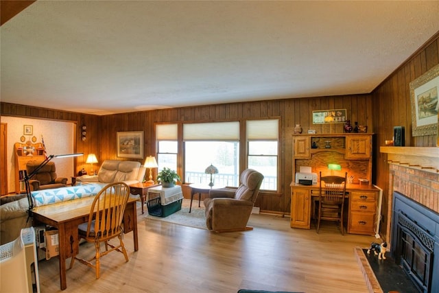 23186 Hatchtown Rd, Spartansburg, PA 16434 - dining area featuring a fireplace, wood walls, and light wood-type flooring