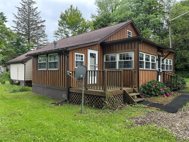 10689 Glenn Blvd, Conneaut Lake, PA 16316 - back of house with board and batten siding, a yard, a wooden deck, and roof with shingles