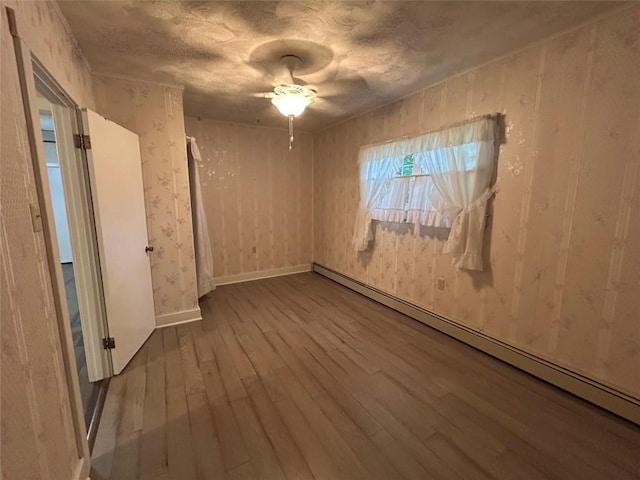 10689 Glenn Blvd, Conneaut Lake, PA 16316 - spare room featuring a baseboard radiator, hardwood / wood-style floors, and a ceiling fan
