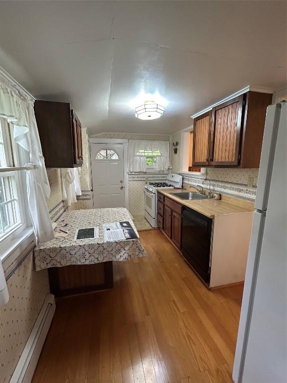 10689 Glenn Blvd, Conneaut Lake, PA 16316 - kitchen featuring white appliances, a baseboard radiator, light wood-type flooring, light countertops, and tasteful backsplash