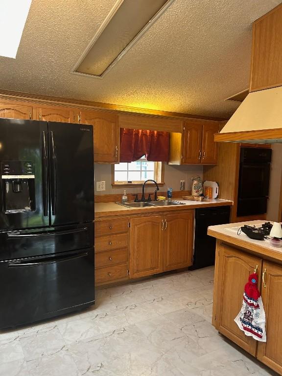 kitchen featuring a textured ceiling, sink, and black appliances