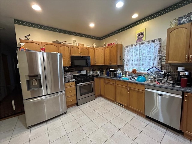 1048 W 6th St, Erie, PA 16507 - kitchen with appliances with stainless steel finishes, dark countertops, light tile patterned flooring, brown cabinetry, and recessed lighting