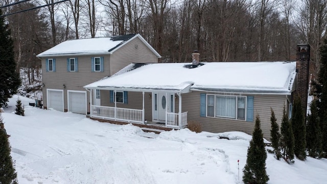 view of front of house featuring a garage, a chimney, and a porch