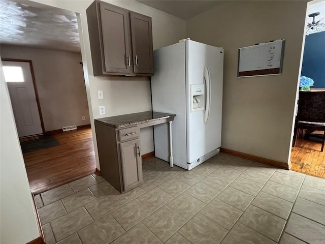 kitchen featuring white fridge with ice dispenser and light hardwood / wood-style floors