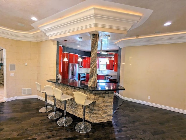 kitchen featuring a breakfast bar area, kitchen peninsula, stainless steel appliances, and dark hardwood / wood-style floors