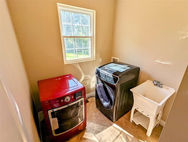 washroom with light tile patterned floors, sink, and washing machine and clothes dryer