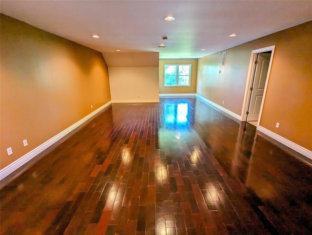 empty room featuring dark hardwood / wood-style flooring and lofted ceiling