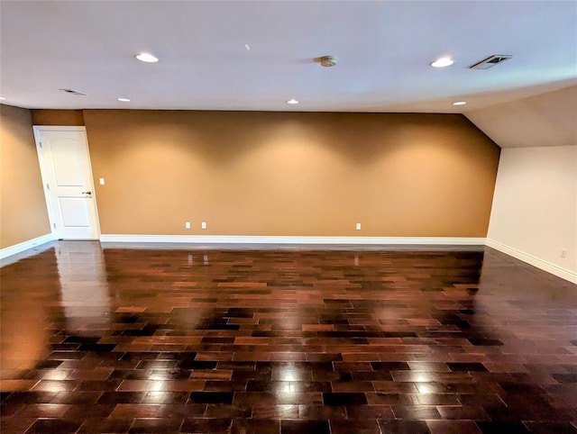 empty room with dark hardwood / wood-style flooring and lofted ceiling