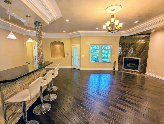 living room with crown molding, dark hardwood / wood-style flooring, a fireplace, and a tray ceiling