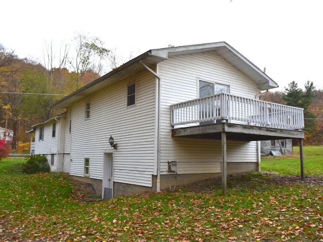 view of property exterior with a lawn and a deck