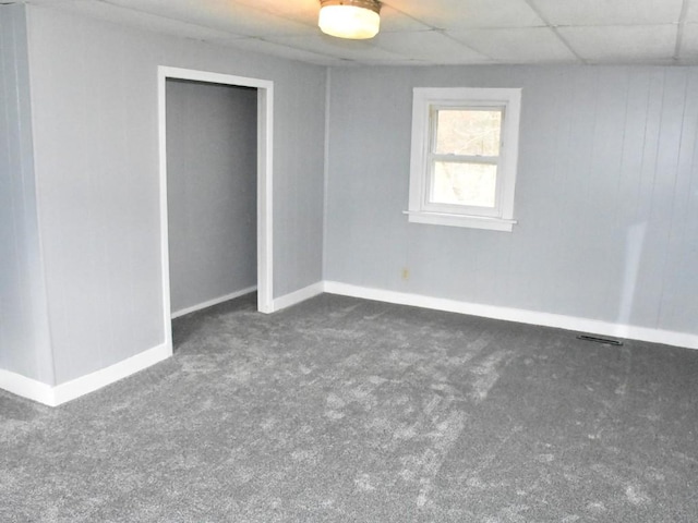 carpeted spare room with a paneled ceiling