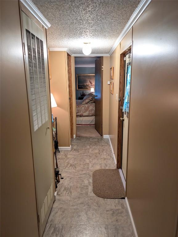 8734 Colonial Ln, Linesville, PA 16424 - corridor featuring ornamental molding, baseboards, a textured ceiling, and a heating unit