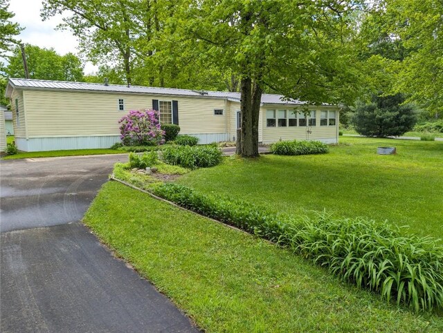 8734 Colonial Ln, Linesville, PA 16424 - manufactured / mobile home with driveway, a front lawn, and metal roof