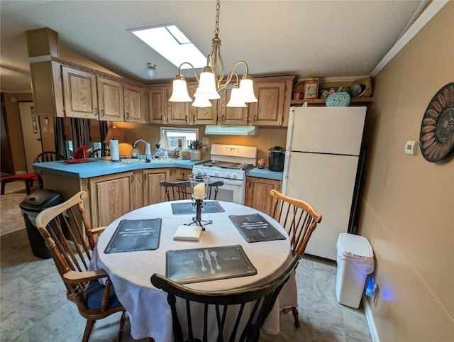 8734 Colonial Ln, Linesville, PA 16424 - kitchen featuring white appliances, under cabinet range hood, a peninsula, vaulted ceiling, and a skylight