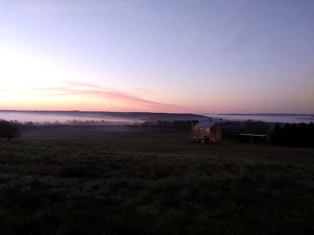 yard at dusk with a rural view