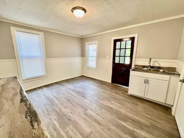 3624 Buffalo Rd, Erie, PA 16510 - unfurnished dining area featuring a textured ceiling, a sink, wainscoting, wood finished floors, and crown molding