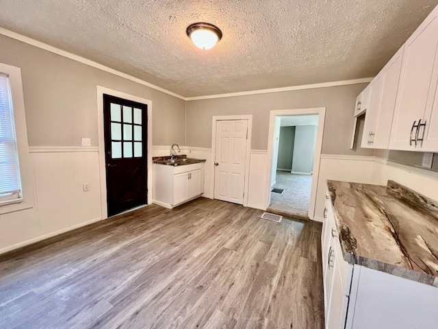 3624 Buffalo Rd, Erie, PA 16510 - kitchen featuring a textured ceiling, wood finished floors, a sink, white cabinets, and a wainscoted wall
