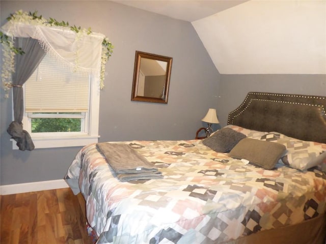 bedroom with vaulted ceiling and hardwood / wood-style floors