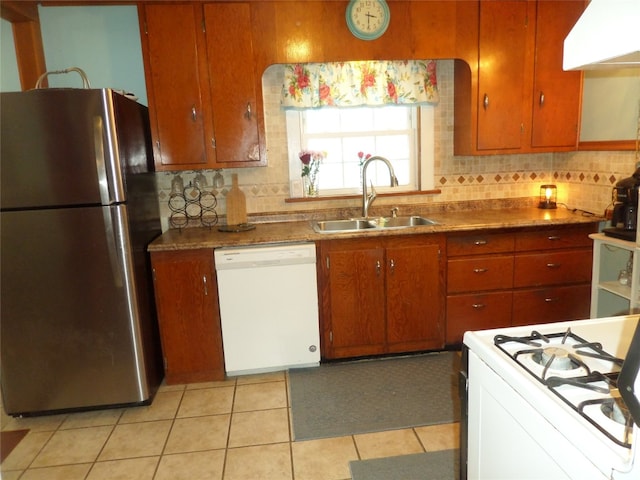 kitchen with sink, tasteful backsplash, light tile patterned floors, white appliances, and range hood