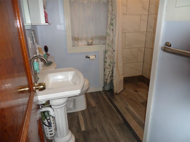 bathroom featuring hardwood / wood-style flooring, toilet, and a shower with shower curtain