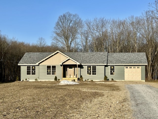 ranch-style house with a garage, roof with shingles, and driveway