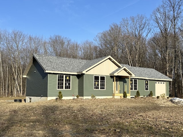 single story home featuring a garage and roof with shingles