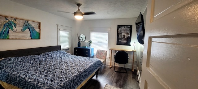 bedroom featuring dark wood-type flooring, ceiling fan, and a textured ceiling