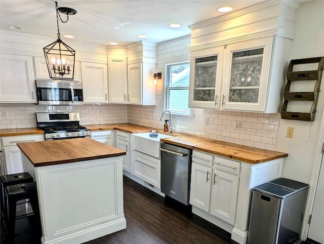 732 Walbridge Rd, Erie, PA 16511 - kitchen with butcher block countertops, appliances with stainless steel finishes, white cabinetry, and a kitchen island