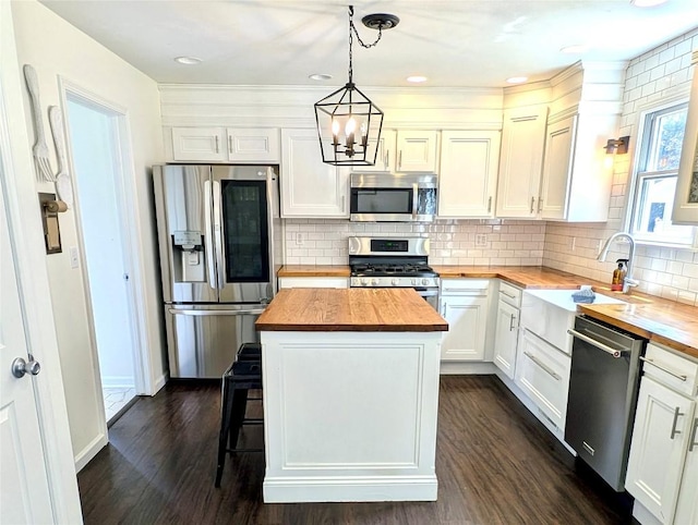 732 Walbridge Rd, Erie, PA 16511 - kitchen with wooden counters, stainless steel appliances, dark wood finished floors, tasteful backsplash, and a chandelier