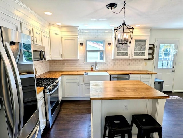 732 Walbridge Rd, Erie, PA 16511 - kitchen with butcher block counters, stainless steel appliances, a kitchen breakfast bar, tasteful backsplash, and recessed lighting