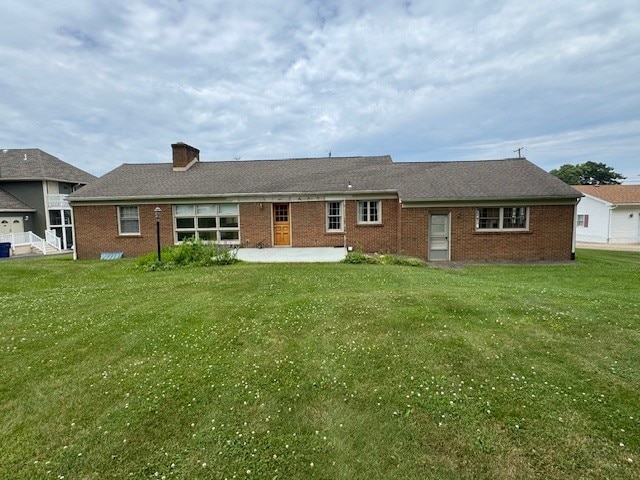 3233 W 26th St, Millcreek, PA 16505 - back of property with brick siding, a patio area, a yard, and a chimney