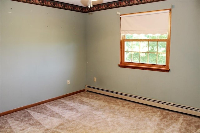 carpeted spare room featuring a baseboard heating unit and baseboards