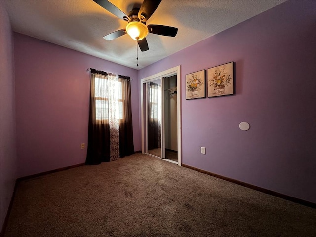 carpeted spare room featuring a textured ceiling and ceiling fan