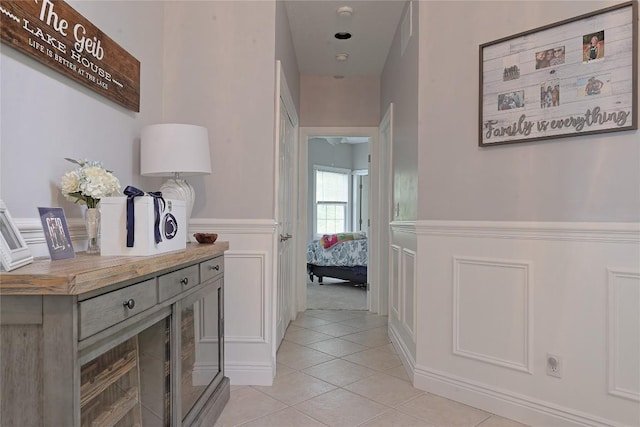 8280 Shore Dr, Fairview, PA 16415 - hallway featuring light tile patterned flooring, wainscoting, and a decorative wall