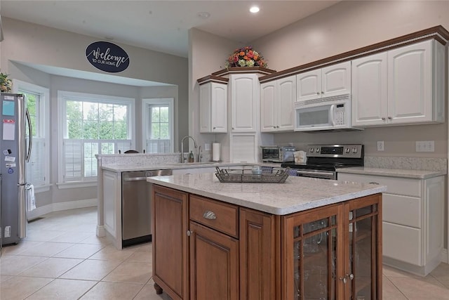 8280 Shore Dr, Fairview, PA 16415 - kitchen with appliances with stainless steel finishes, light tile patterned flooring, white cabinets, a peninsula, and recessed lighting