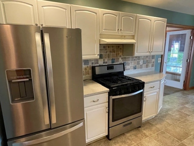 kitchen with light tile patterned flooring, range hood, decorative backsplash, white cabinets, and appliances with stainless steel finishes