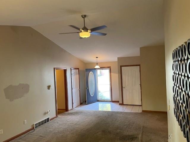 foyer entrance featuring ceiling fan, light colored carpet, and lofted ceiling