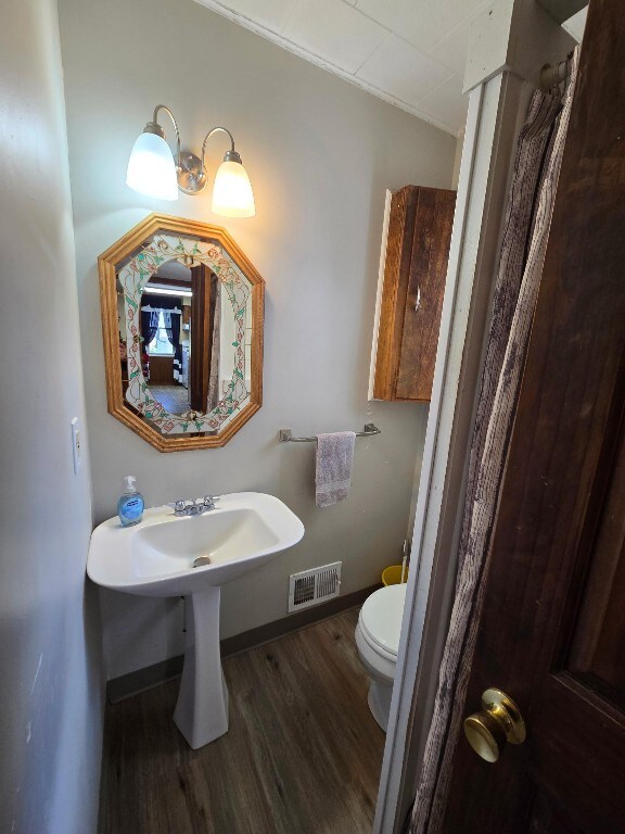 10827 Springs Rd, Meadville, PA 16335 - bathroom featuring toilet, wood finished floors, visible vents, and baseboards