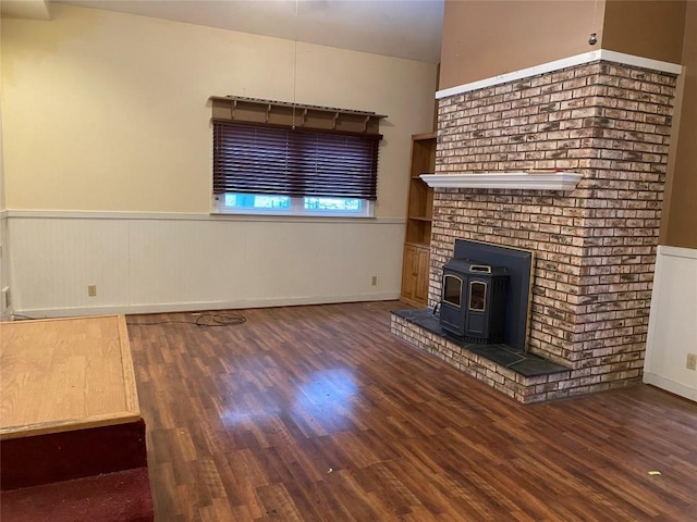 unfurnished living room featuring a wood stove and dark wood-type flooring